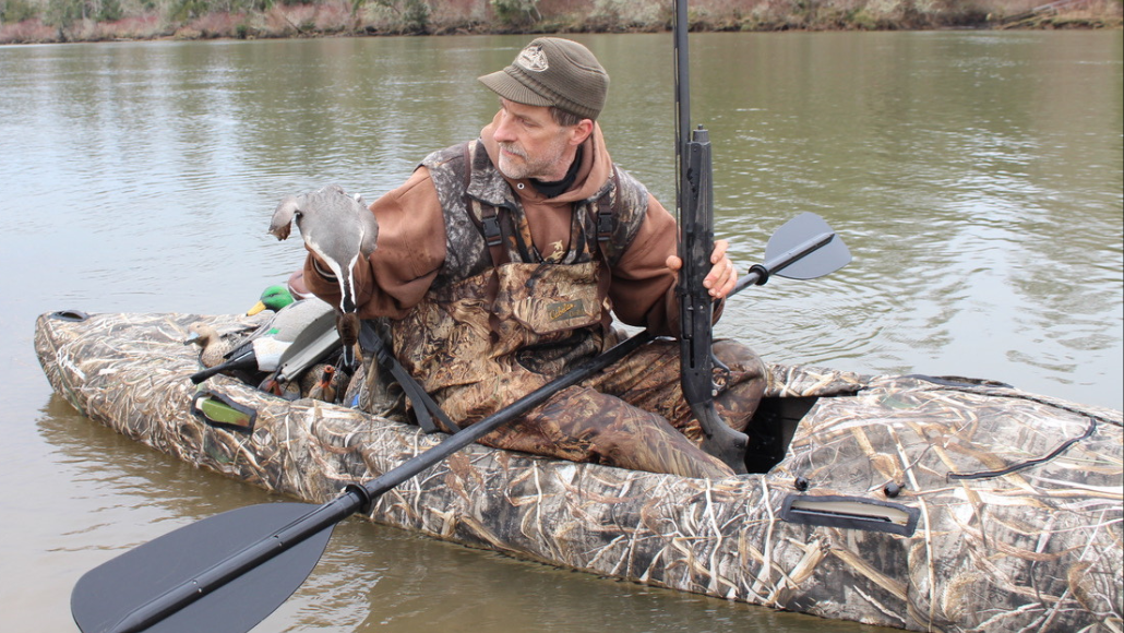 Duck hunter in camo boat on the water duck hunting