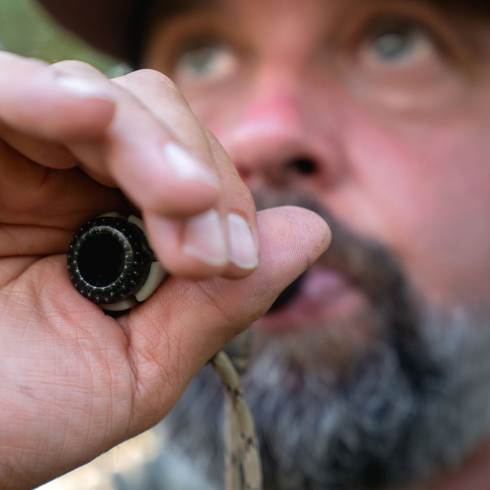 A close up view of a duck hunter blowing the single reed ATC - Muller Chokes collaboration duck call.
