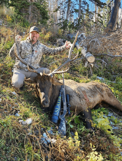 Hunter with elk in woods