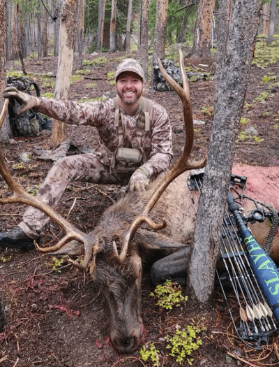 Hunter in woods with elk