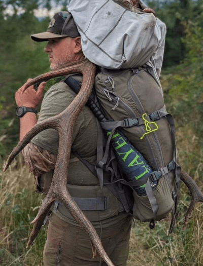 Hunter in woods with elk antlers