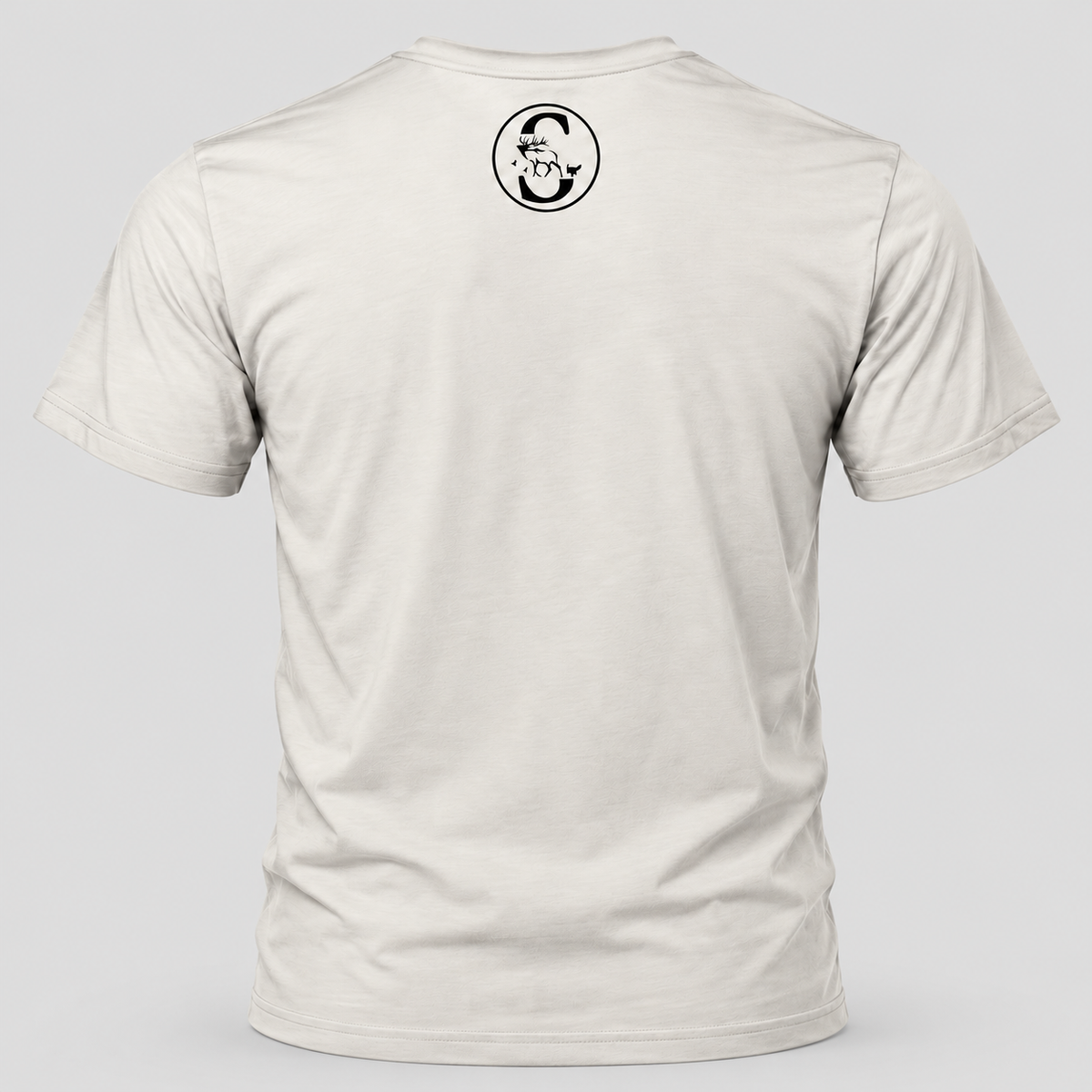 A light beige crewneck t-shirt shown from the back, featuring a small black Slayer 'S' circular logo printed on the upper back. The t-shirt is displayed on a neutral light gray background.