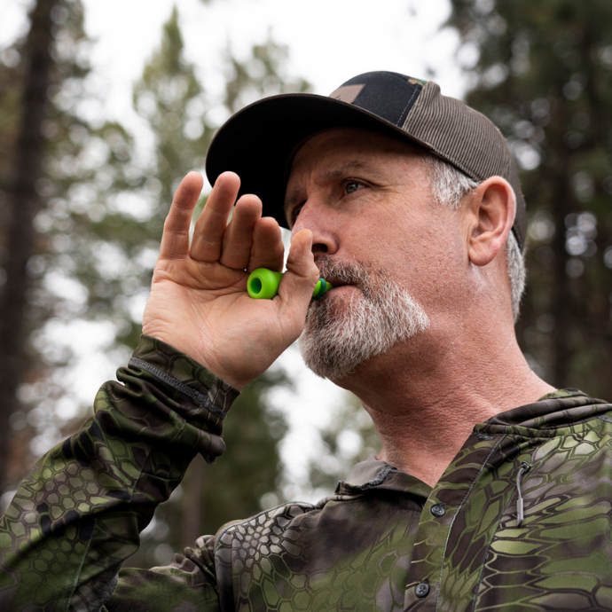 Elk in hunter in the field blowing the green External Calf call by Slayer Calls.