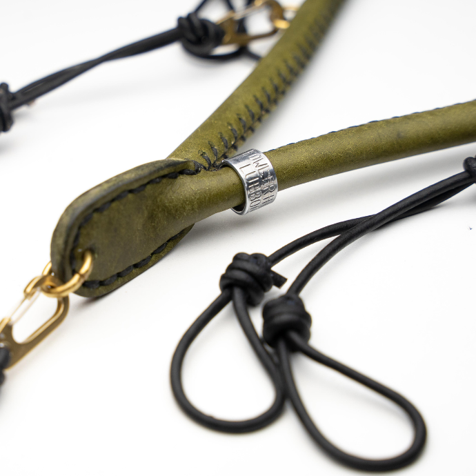 Close-up of a moss green leather lanyard with gold and silver hardware on a white background