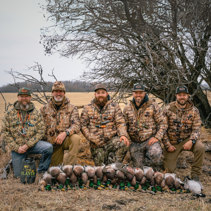 Slayer Calls grey Dry Bag with "Call the Wild" design, shown with the Slayer team in the field posing with their duck limits.