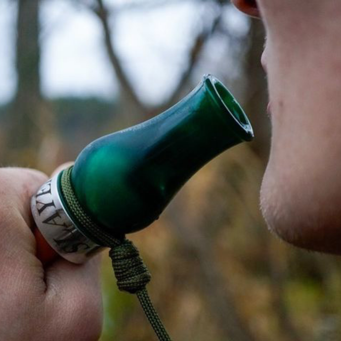 Close-up of a hunter using the Slayer DUBAR single reed duck call in Green Pearl, designed for sharp tone control and high-volume calling in diverse hunting conditions.