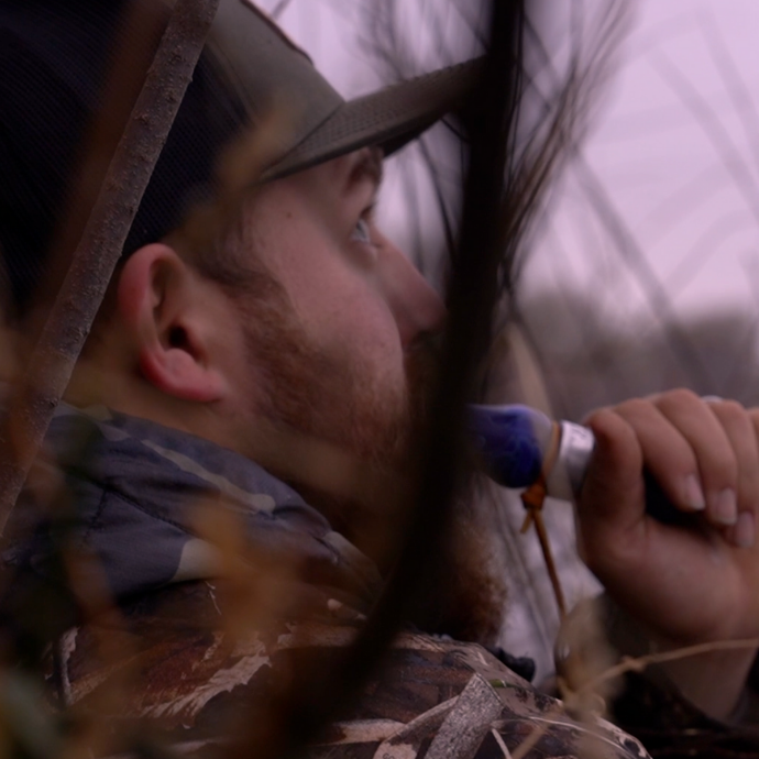Waterfowler hidden in the blind running the Ranger Single Reed duck call in Blue Wing Mesh acrylic | Slayer Calls