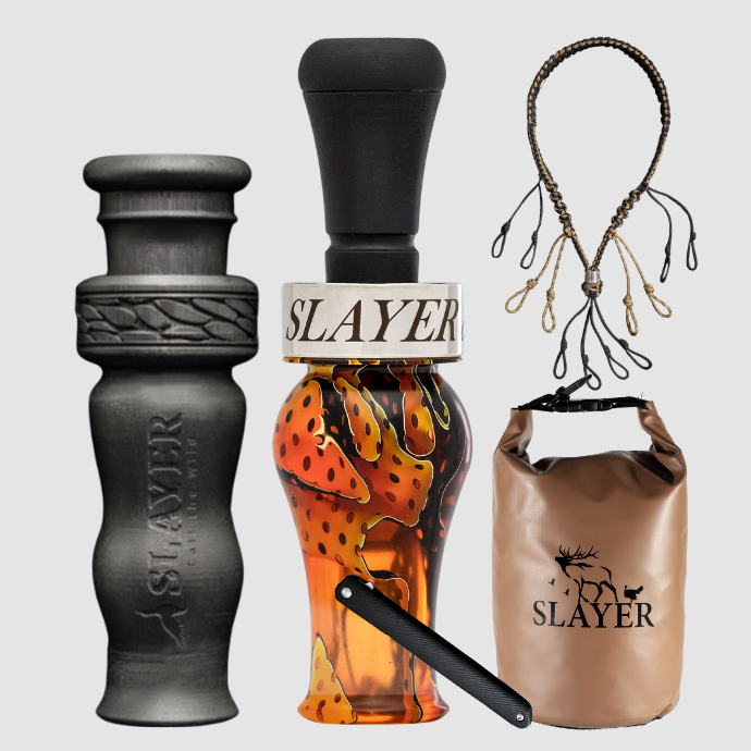 Slayer Calls duck call and duck whistle collection with Slayer's DUBAR Slayer duck call in orange acrylic, 4-in-1 duck whistle, lanyard, field dressing tool, and dry bag featuring SLAYER logo.