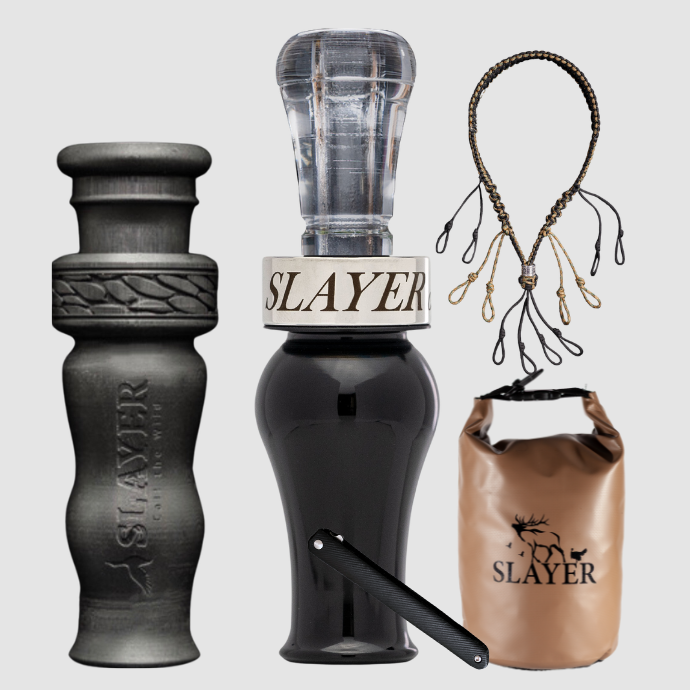 Slayer Calls duck call and duck whistle bundle with Slayer's double reed Drake Slayer duck call in black acrylic, 4-in-1 duck whistle, lanyard, field dressing tool, and dry bag featuring SLAYER logo.