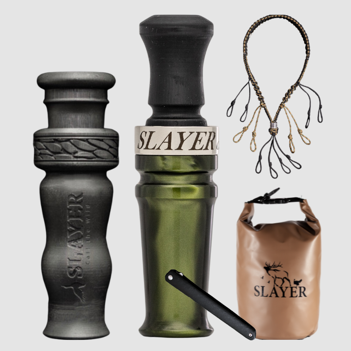 Slayer waterfowl bundle featuring green ghost acrylic duck call, black 4 in 1 duck whistle, dry bag, field dresser and lanyard on a light background.