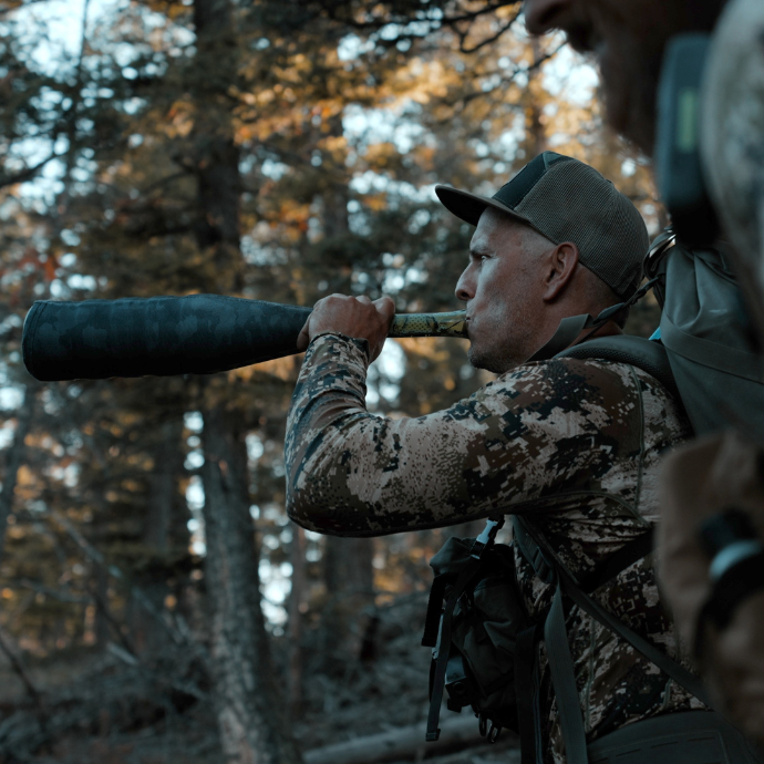 Elk hunter dressed in camo, bugling with the ArchAngel elk bugle tube in the field