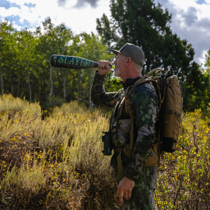 Elk hunter in the field bugling using the miner elk reed and the ArchAngel elk bugle tube from Slayer Calls