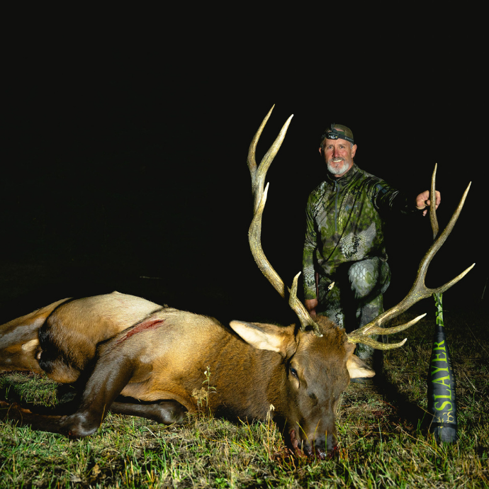 Slayer CEO - Bill Ayer, with harvested bull elk after using Slayer Calls’ ArchAngel bugle tube and Clearwater Series reeds in rugged mountain terrain at night.