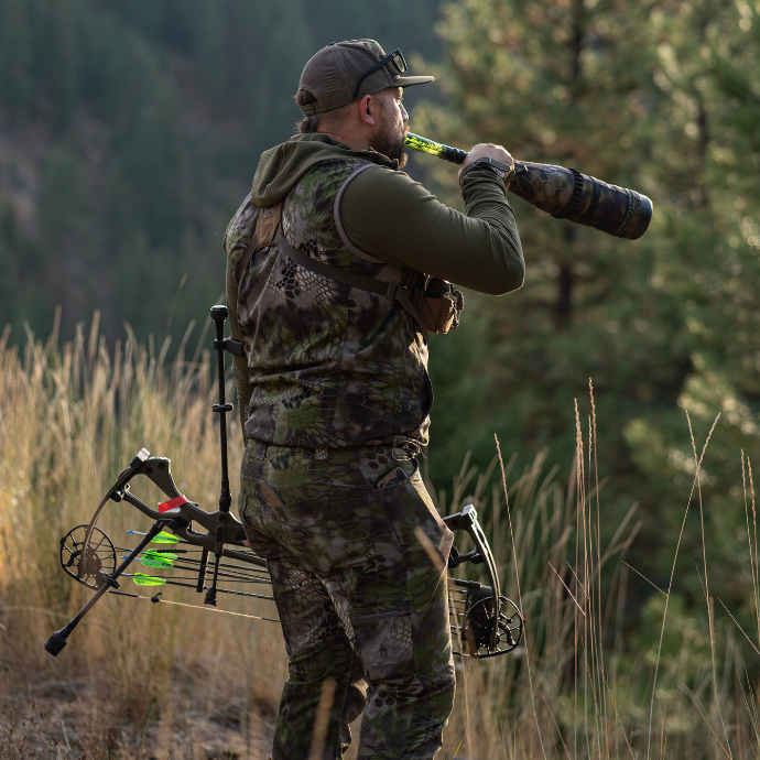 Cody McCarthy bugling with the ArchAngel bugle tube, holding a Hoyt bow in the elk woods.