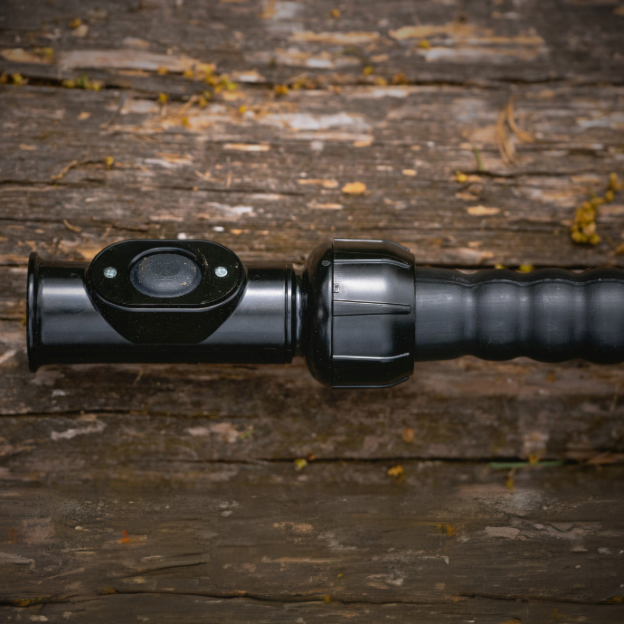 Close up of the Enchantress cow call attached to the mouth of the Swagger bugle tube against a wood backdrop.