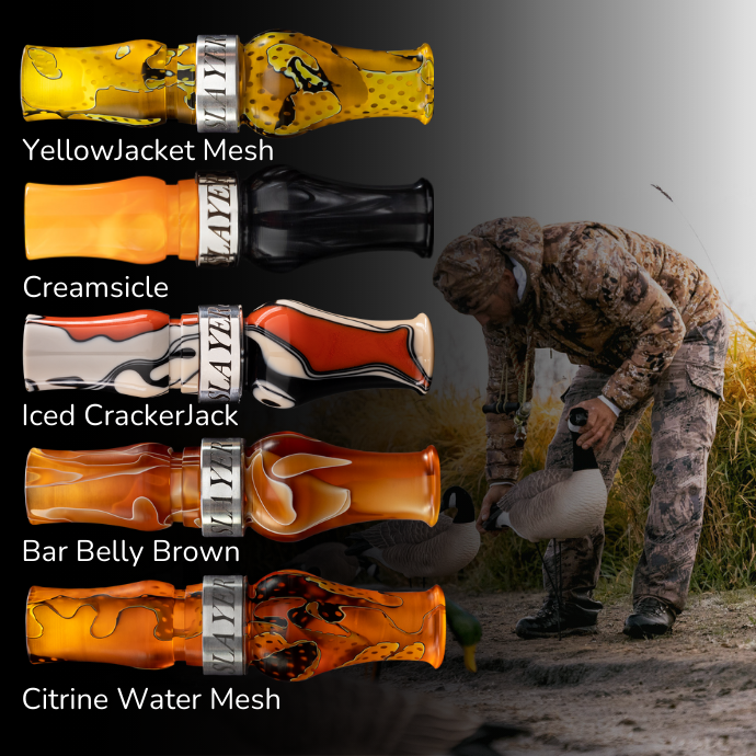 Slayer’s Tar Belly specklebelly goose calls displayed in five custom finishes — YellowJacket Mesh, Creamsicle, Iced CrackerJack, Bar Belly Brown, and Citrine Water Mesh — with a hunter setting decoys in the background.