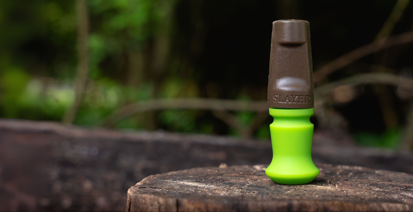 The Harem hands free elk call, bite call from Slayer Calls pictured in the elk woods in brown and Slayer green