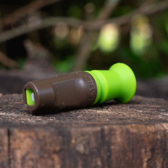 the green and brown slayer harem hands free elk call on top of a tree stump