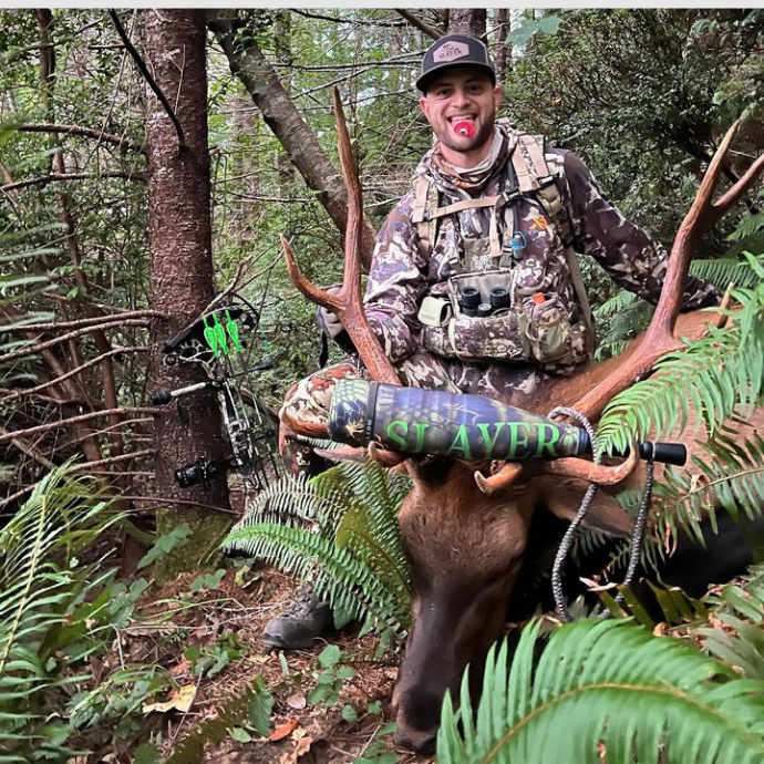 Elk hunter posing with mature harvested bull using Slayer's Miner elk reed and Swagger bugle tube
