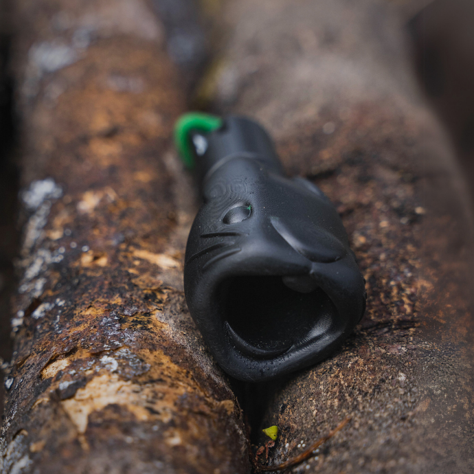 Wicked Rabbit predator call by Slayer Calls resting on tree bark — durable, field-ready distress call designed to lure coyotes and other predators with realistic rabbit sounds.