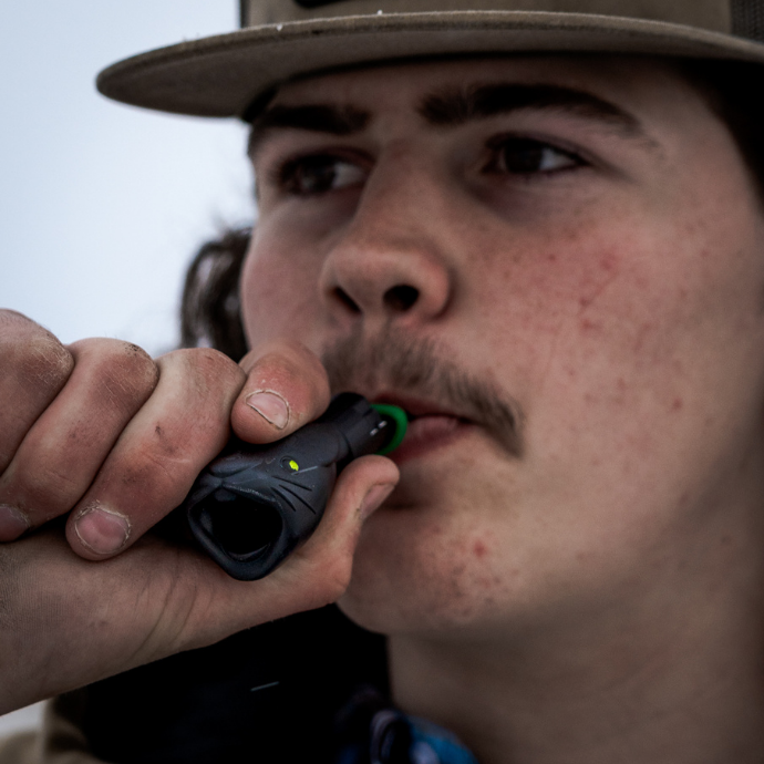 Hunter using the Wicked Rabbit predator call from Slayer Calls — close-up of coyote call in action, engineered to mimic distressed rabbit sounds for predator hunting success.