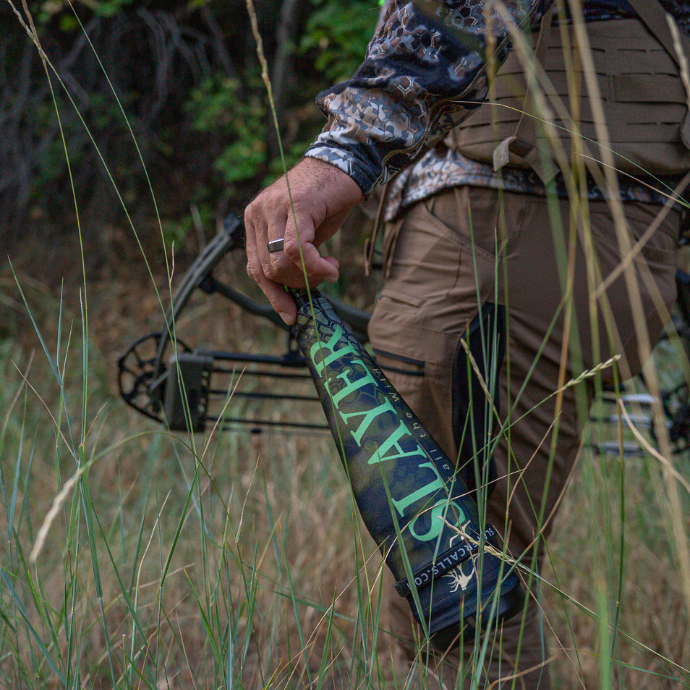 Elk hunter in camo holding the Guardian bulge tube by Slayer Calls and a bow.