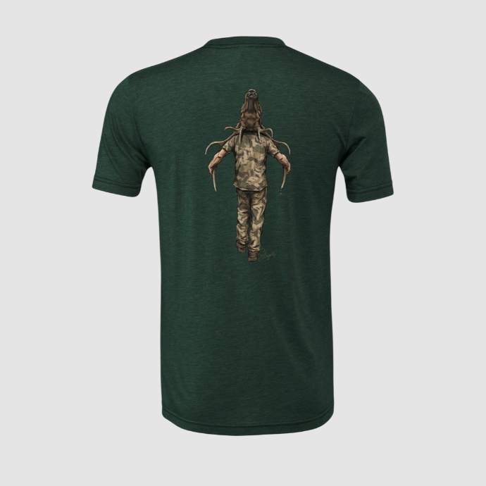 Green t-shirt with a graphic of an elk hunter in camouflage packing out a harvested bull on his back against a light gray background.