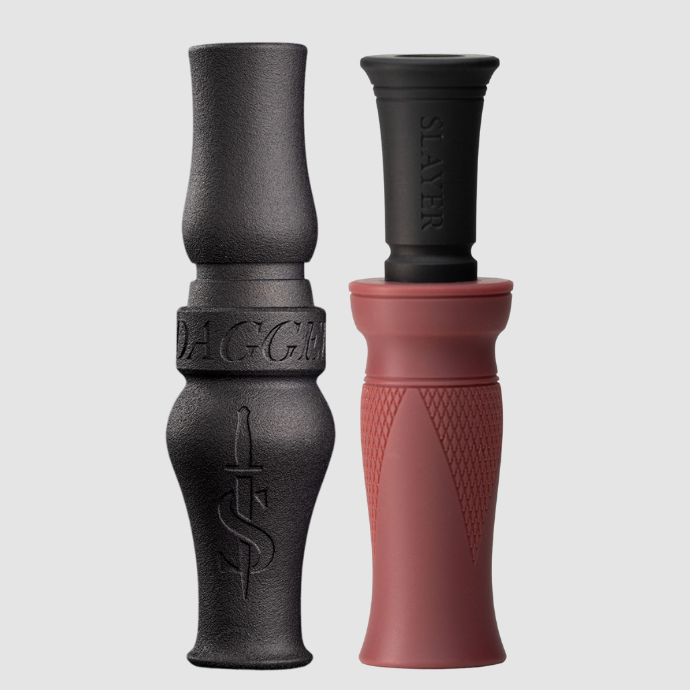 Two waterfowl calls, one black goose call and one washed red duck call, on a light gray background.