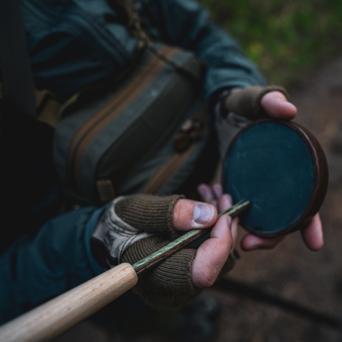 Turkey hunter using a slate pot call in the turkey woods.
