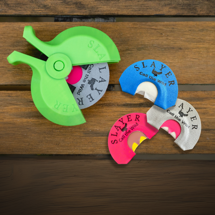 Slayer Calls Reed PAC’r with five turkey diaphragm calls, including the Cutter, Quad Hen, Grey Batwing, and Fang Cutter, displayed on a wooden surface.