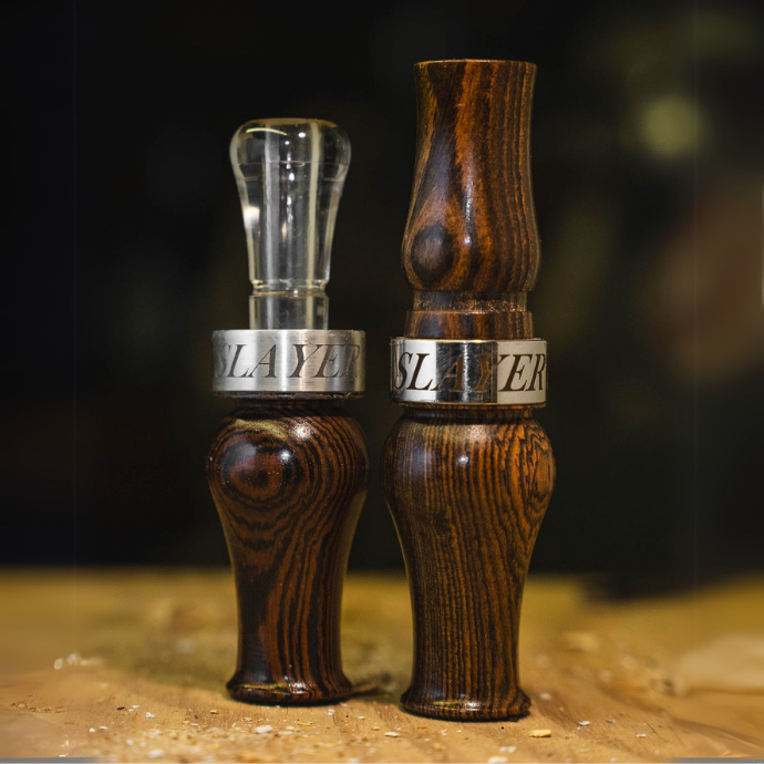 Slayer’s Axe Honker goose call and Suzie Slayer duck call crafted in premium bocote wood with polished metal bands — precision-tuned for rich, natural tones. Matching goose duck call combo.