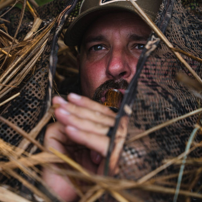 Goose hunter concealed in a blind blowing Slayer’s Axe Honker call — a hand-tuned wood goose call built for deep, raspy honks and close-range finishes.