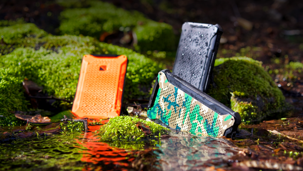 an orange and black cell phone portable power pack sitting in a stream of water
