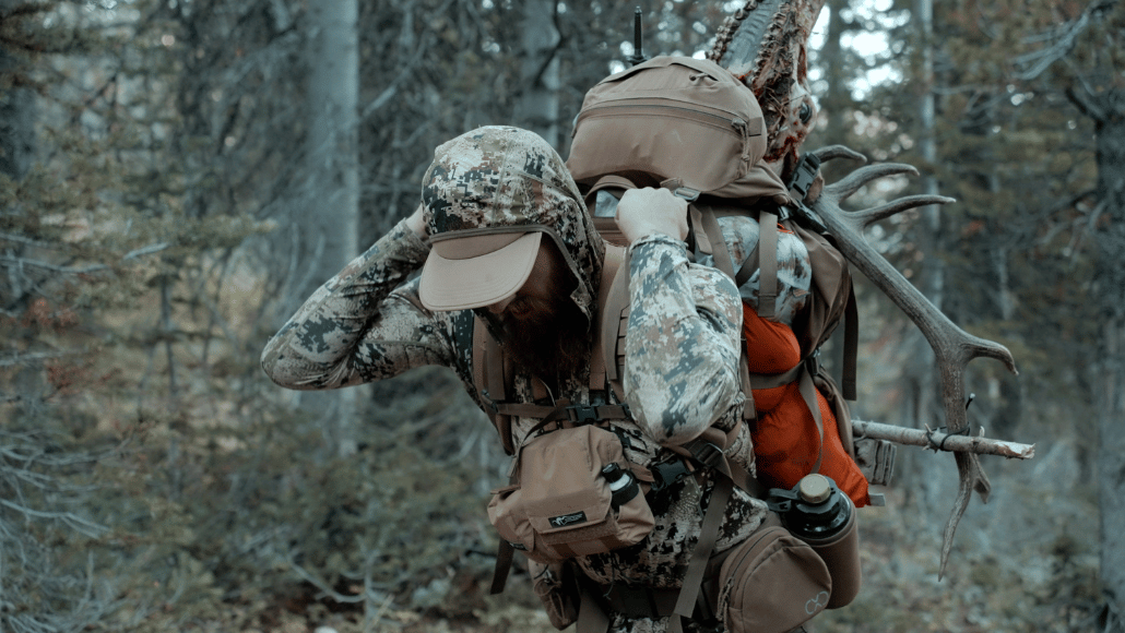 Elk hunter, Steve Raudenbush walking through the woods packing out harvested elk called in using Slayer's ArchAngel elk bugle tube and Clearwater reeds.