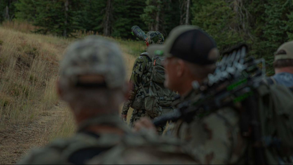 Elk hunters surveying the elk woods with on hunter blowing an elk bugle