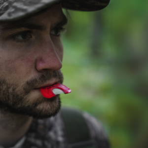 Turkey hunter with the Straight Cut turkey reed in his mouth against a blurred natural background