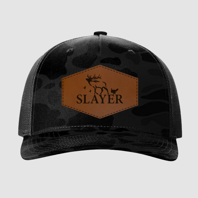 Black camouflage cap with a brown leather patch featuring the word 'SLAYER' 