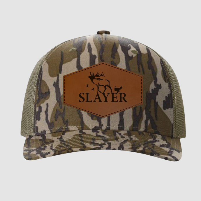 Mossy Oak Bottomland Camouflage cap with a brown leather patch featuring the Slayer logo