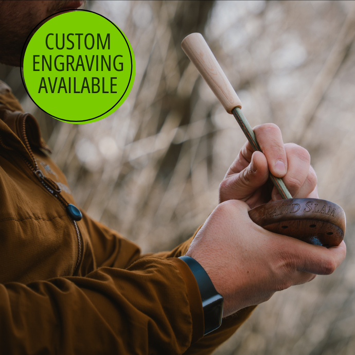 Turkey hunter using Slayer  pot call with custom engraving  shown on the wood band, set against a natural background.