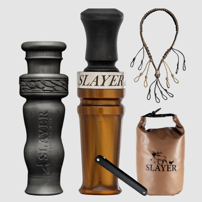 Slayer waterfowl bundle featuring kodiak copper acrylic duck call, black 4 in 1 duck whistle, dry bag, field dresser and lanyard on a light background.