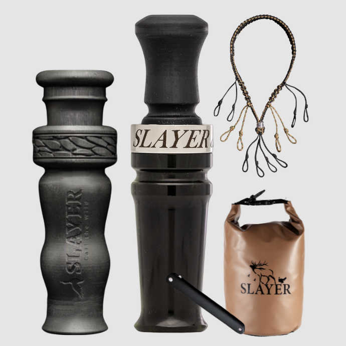 Slayer waterfowl bundle featuring black acrylic duck call, black 4 in 1 duck whistle, dry bag, field dresser and lanyard on a light background.