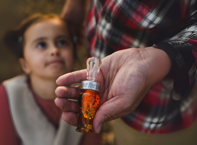 Dad and daughter pictured with a custom duck call from Slayer Calls. The band of the duck call is engraved with LOVE YOU DAD. 