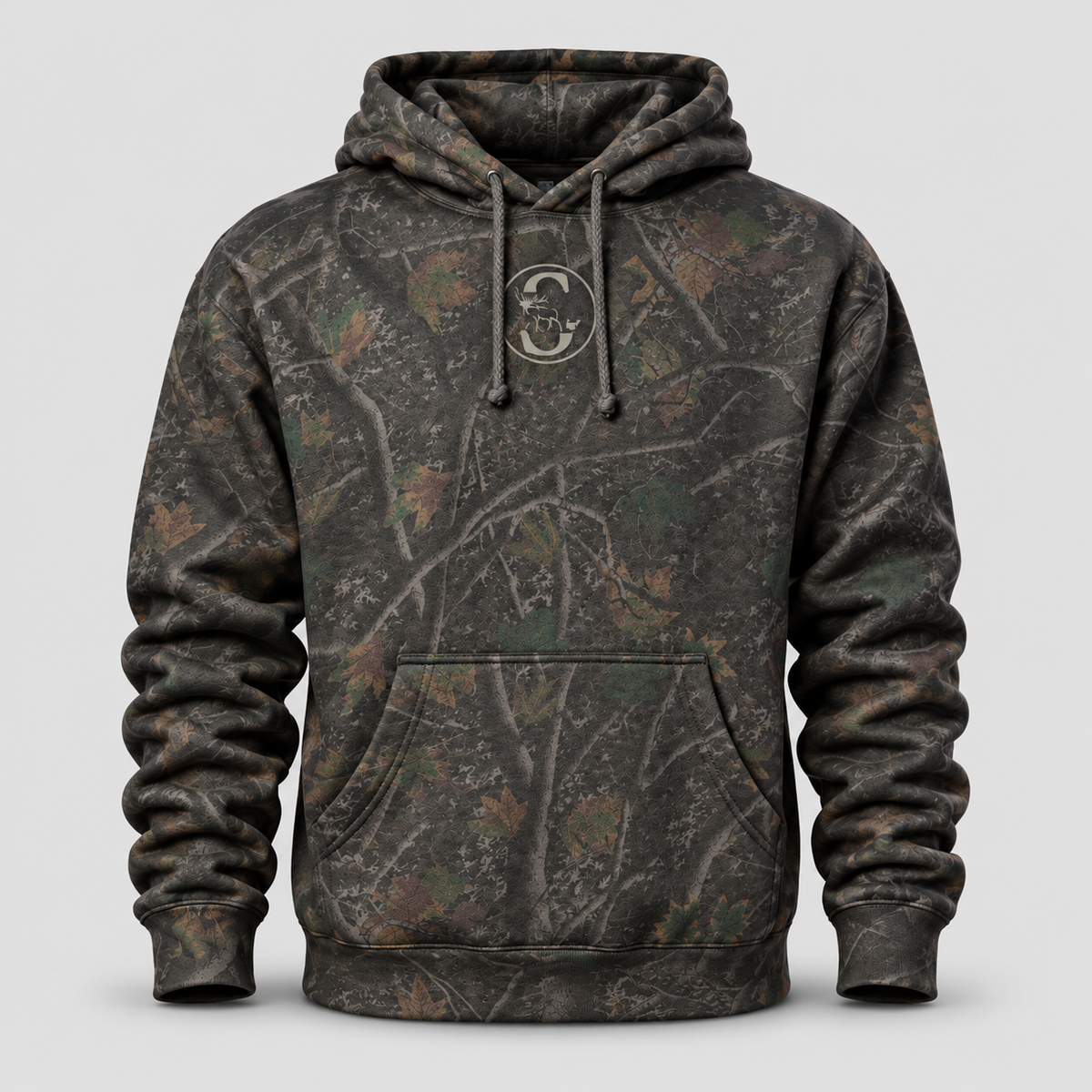 Front view of the Slayer Timberline Heavyweight Hoodie in dark woodland camouflage with realistic tree branch and leaf patterns, a subtle chest logo, adjustable drawstrings, kangaroo pocket, and ribbed cuffs.