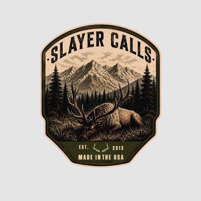 A vintage-style illustrated patch or sticker with the text 'SLAYER CALLS' at the top, showing a mountain range, pine trees, and a large harvested bull elk in the foreground. Smaller text at the bottom reads 'EST 2013.