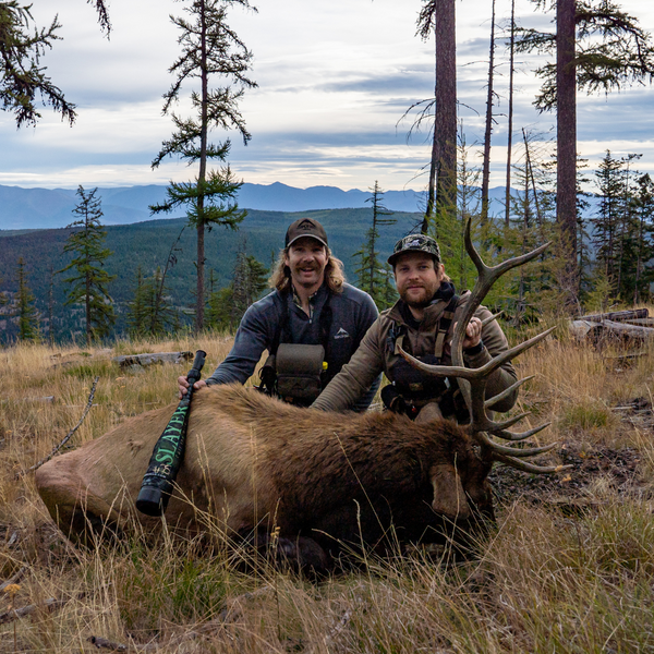 Two hunters in woods with elk call and elk