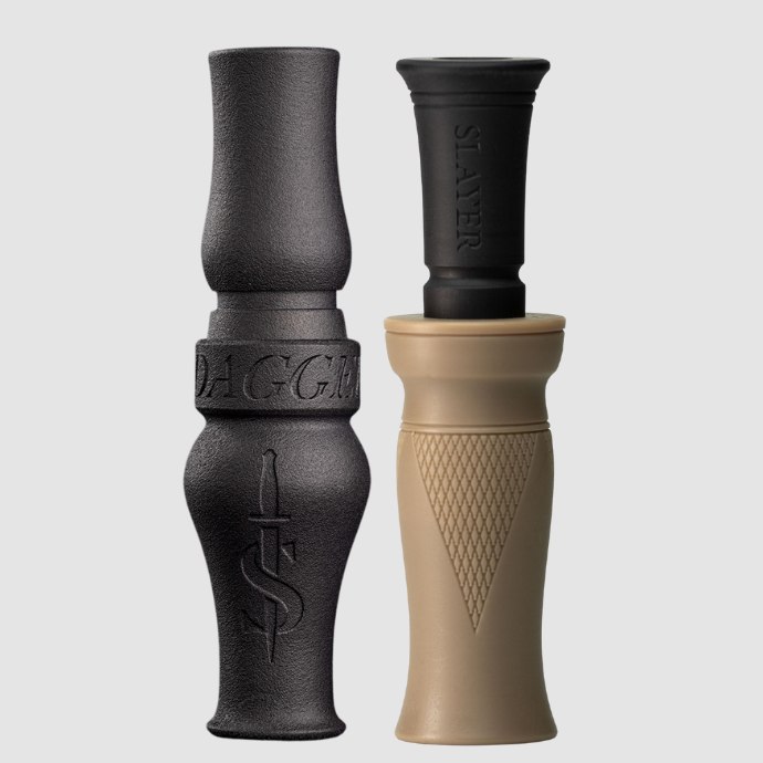 Two waterfowl calls, one black goose call and one green sand colored call, on a light gray background.