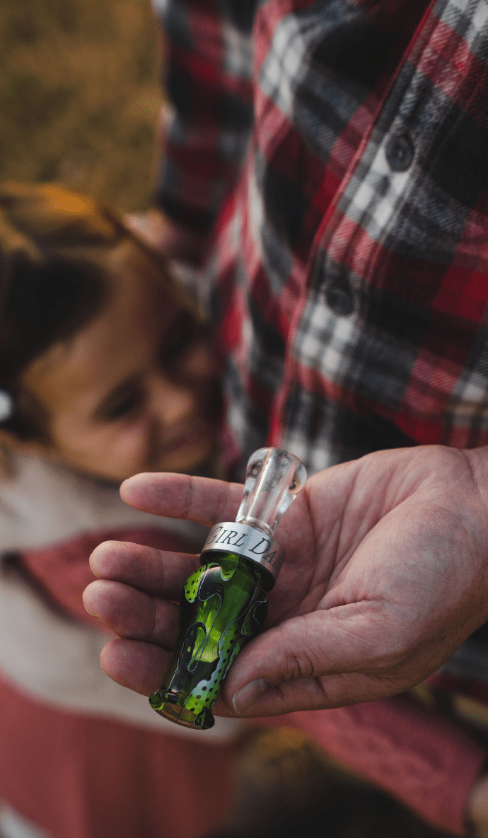 Man holding custom drake slayer double reed duck call with kid