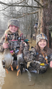 two young girls wearing camo with the drake slayer single reed duck call on lanyards