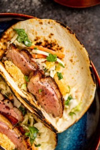 Plated duck tacos with orange and cabbage slaw