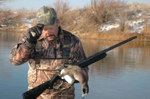 Duck hunter holding a Widgeon, aka Whistling duck